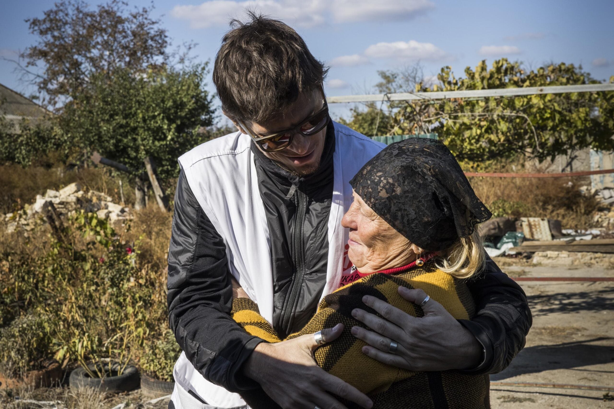 A Doctors Without Borders employee supports a woman, in Mykolaiv, Ukraine, after a Russian missile destroyed her house, on October 10, 2023. Photo courtesy of Doctors Without Borders.